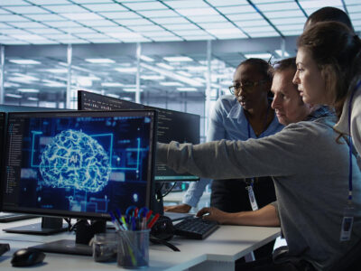 Equipo de trabajo colaborando mientras sistemas digitales inteligentes automatizan procesos y muestran información relevante en segundo plano.