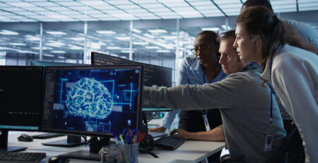 Equipo de trabajo colaborando mientras sistemas digitales inteligentes automatizan procesos y muestran información relevante en segundo plano.